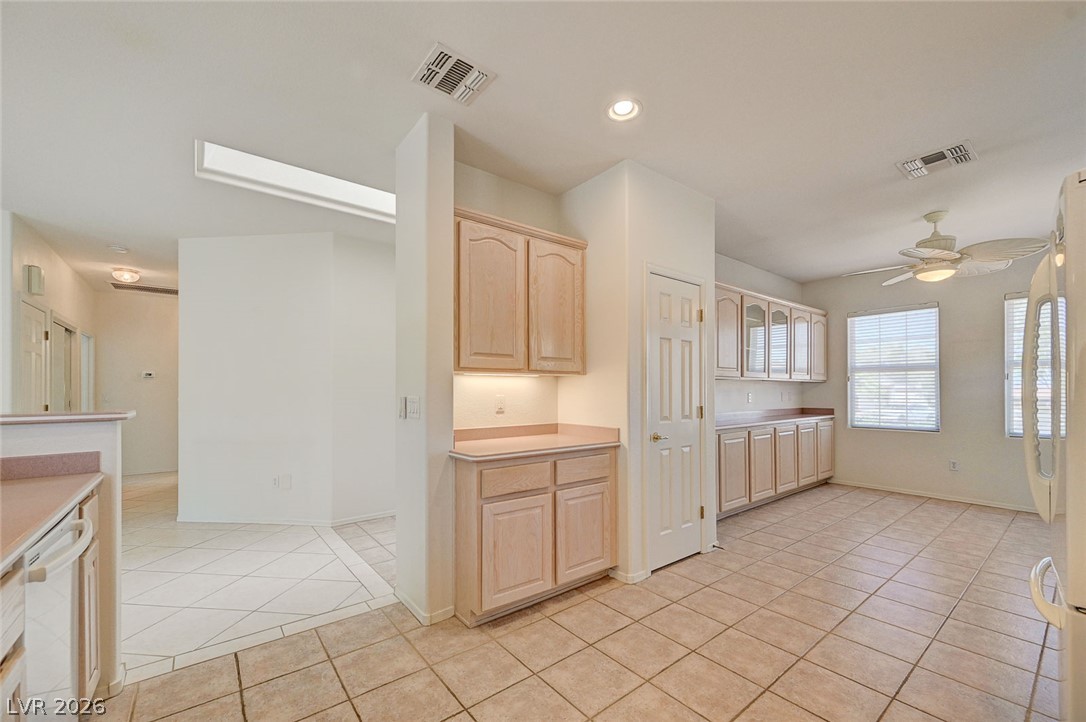 2529 Springville Way Henderson, NV 89052 - Photo 19 of 70 Tiled flooring and wood cabinetry define this functional kitchen space complete with built-in storage options.