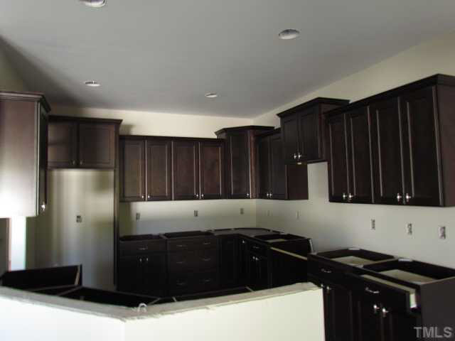 4221 Prelude Street Raleigh, NC 27616 - Photo 6 of 21 Well appointed kitchen with 42" cabinets w/ crown, granite countertops, tile backsplash, recessed lights, hardwood floors