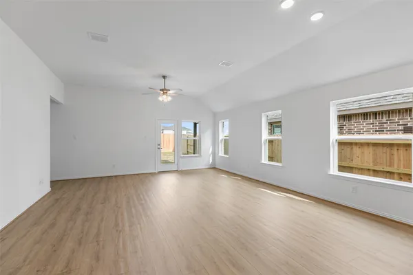 a view of a big room with wooden floor and windows
