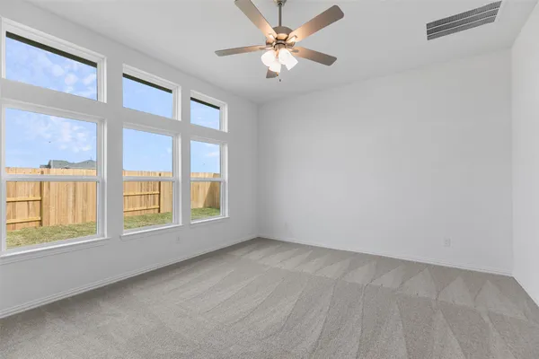 a view of a big room with windows and chandelier fan