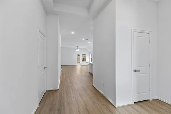 a view of a hallway with wooden floor
