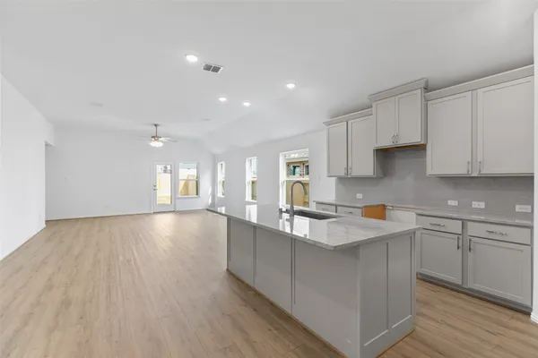 a large kitchen with stainless steel appliances granite countertop a refrigerator and a stove top oven