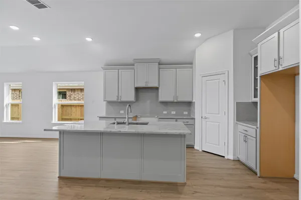 a kitchen with a sink white cabinets and stainless steel appliances