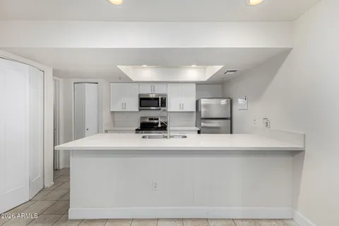 a kitchen with stainless steel appliances a sink stove refrigerator and cabinets