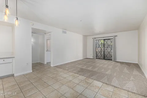a view of an empty room with wooden floor and windows