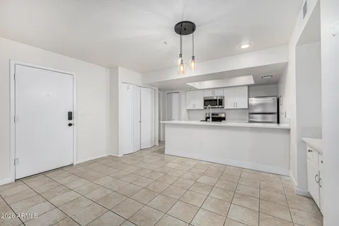 a kitchen with white cabinets a sink stove and refrigerator