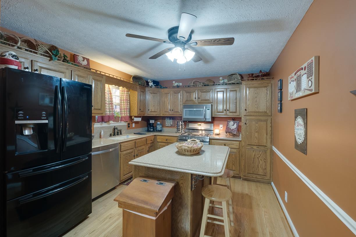 203 Link Road Cottontown, TN 37048 - Photo 18 of 30 a kitchen with a refrigerator a stove and a dining table with wooden floor