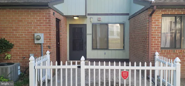 a view of a brick house with wooden fence