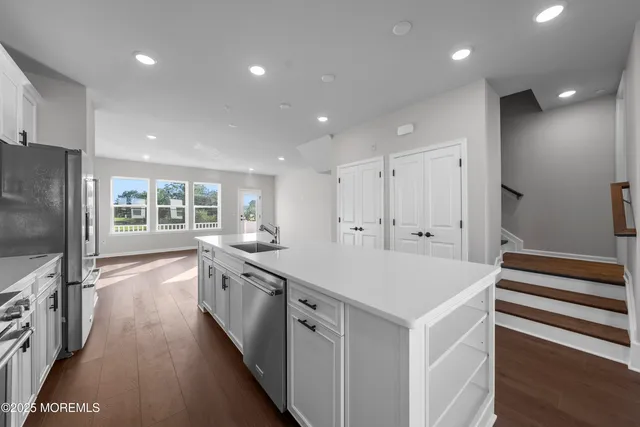 a view of an empty room with wooden floor and closet