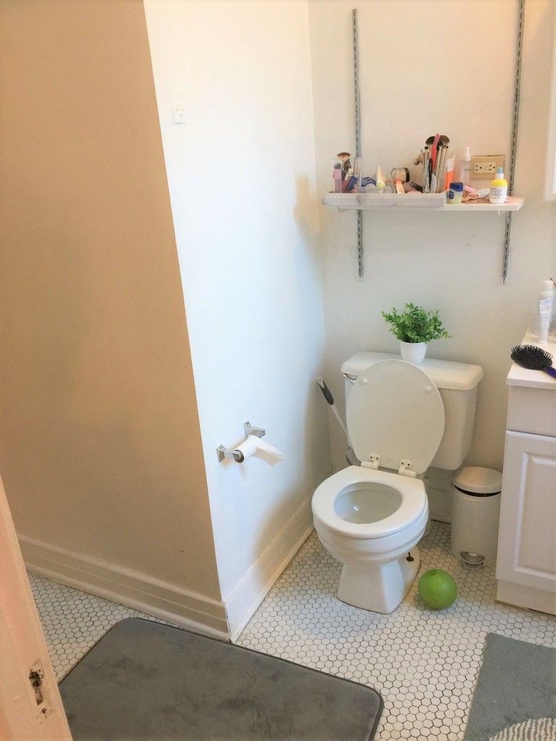 638 West Roscoe Street, Unit 3 Chicago, IL 60657 - Photo 13 of 13 a white toilet sitting next to a sink and vanity