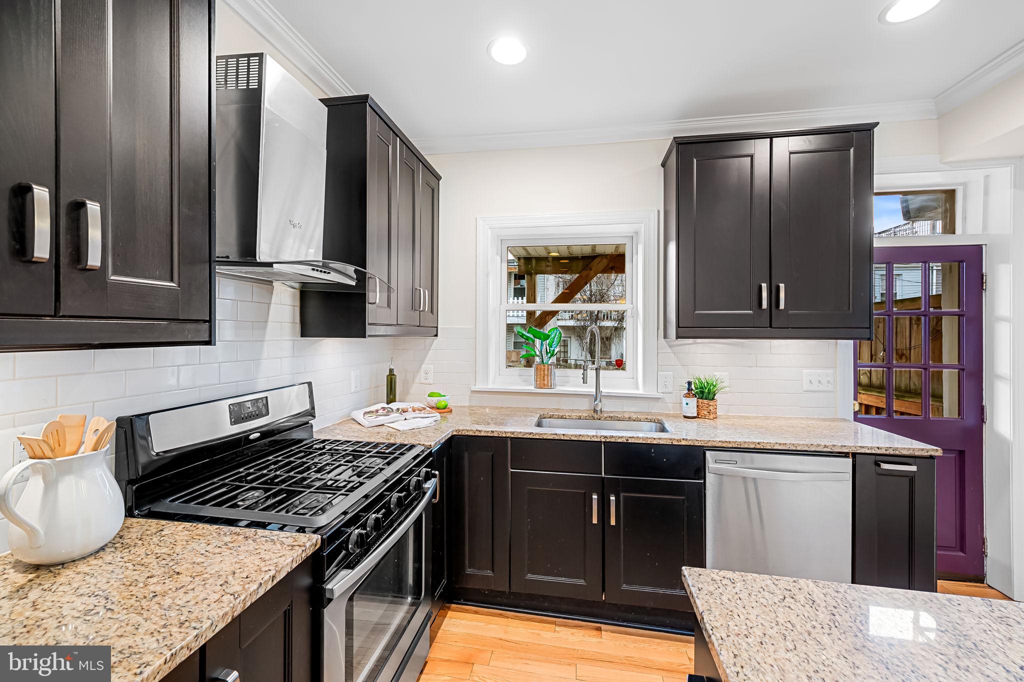 116 Rochester Place Baltimore, MD 21224 - Photo 14 of 45 a kitchen with stainless steel appliances granite countertop a stove a sink and a microwave