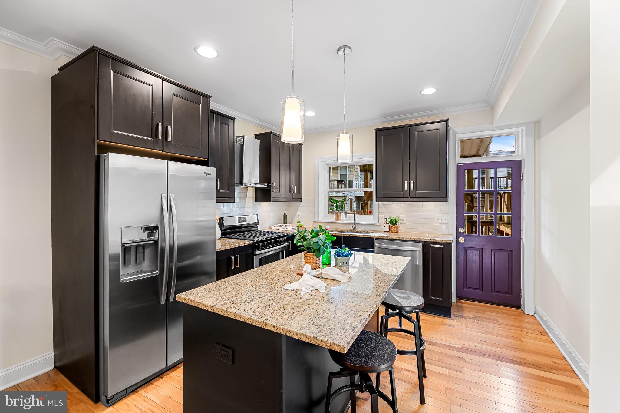 116 Rochester Place Baltimore, MD 21224 - Photo 15 of 45 a kitchen with stainless steel appliances granite countertop a refrigerator a stove a sink a dining table and chairs