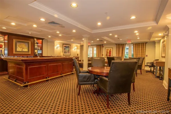 a living room with furniture a wooden floor and kitchen view