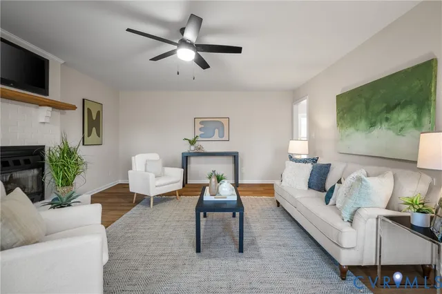 a living room with furniture a clock potted plant and a window