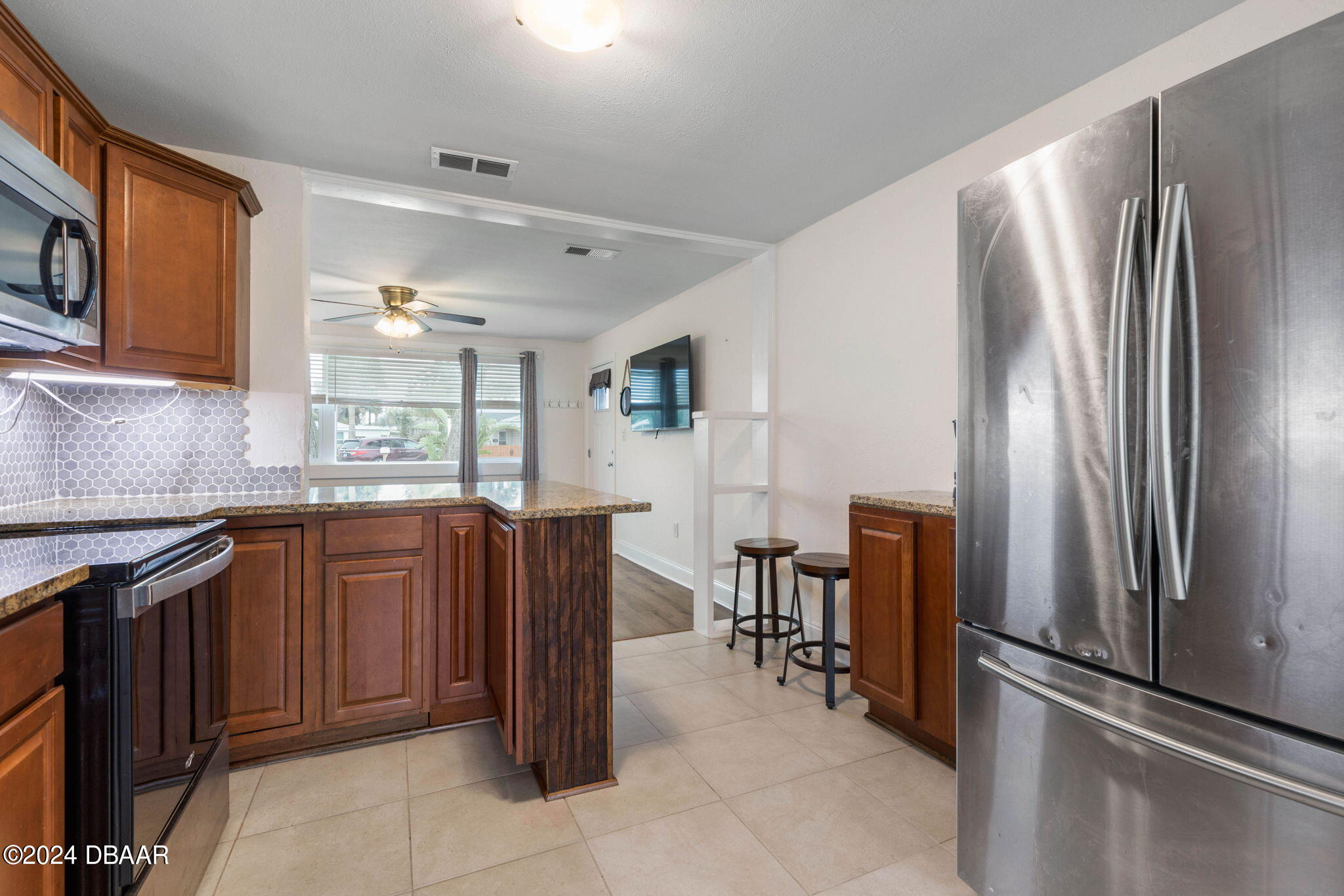 9 Palm Drive Ormond Beach, FL 32176 - Photo 13 of 47 a kitchen with stainless steel appliances granite countertop a refrigerator and a stove top oven