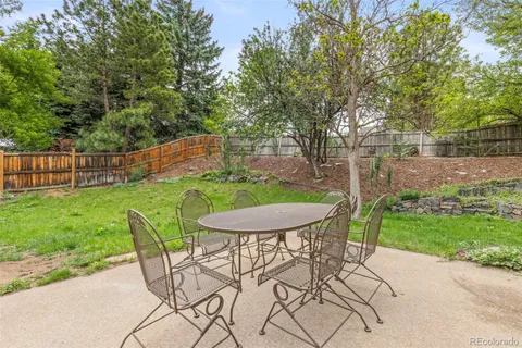 a view of a backyard with furniture and garden