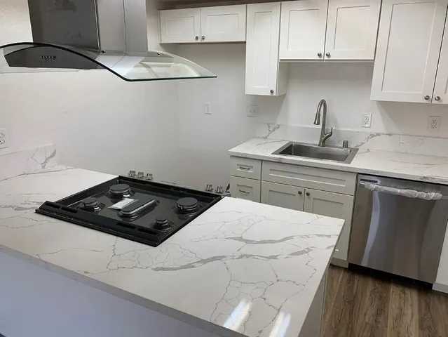 a kitchen with a sink a stove and cabinets