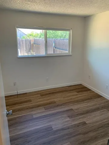 a view of a small space with wooden floor and a window