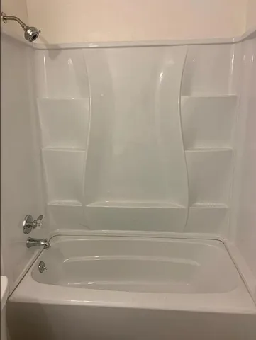 a backyard of a house with plants and large trees