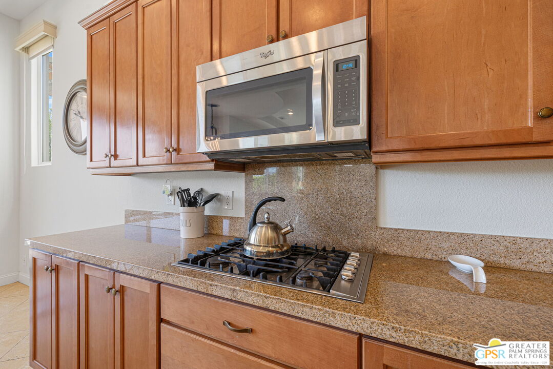 88 Vía Las Flores Rancho Mirage, CA 92270 - Photo 34 of 65 a kitchen with granite countertop white cabinets and a stove top oven