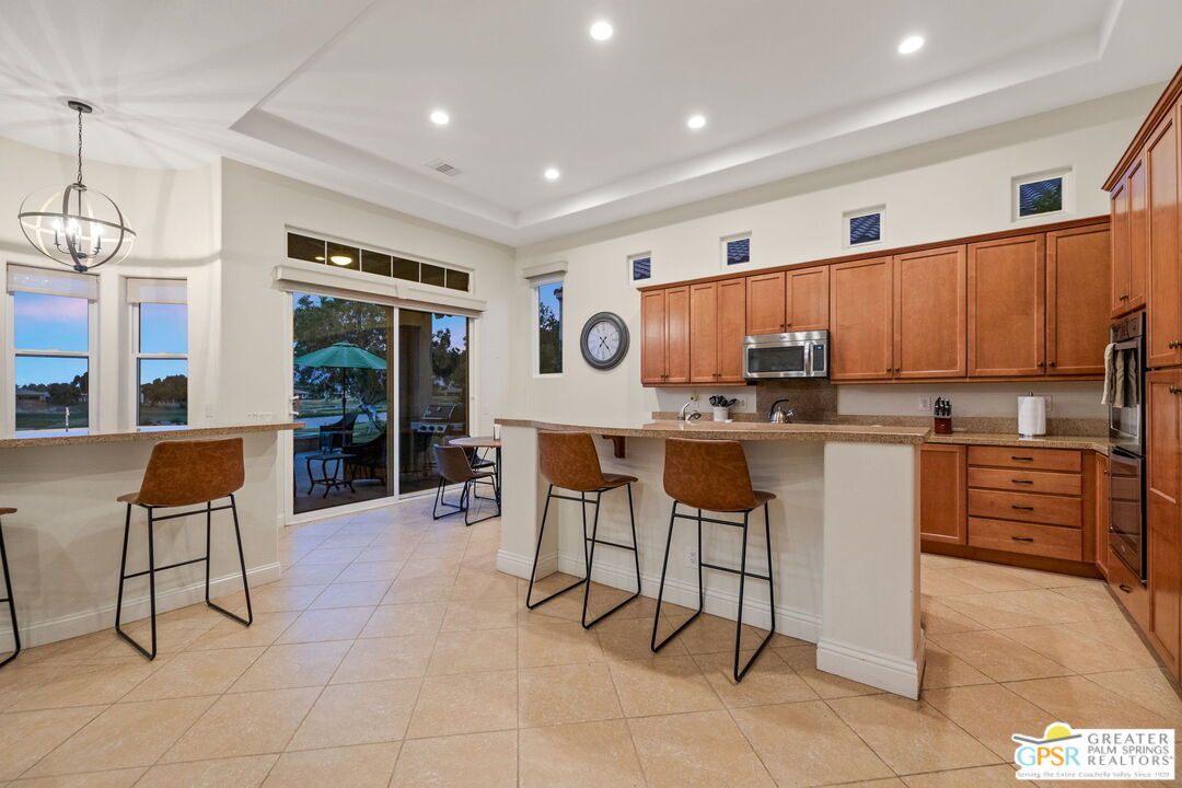88 Vía Las Flores Rancho Mirage, CA 92270 - Photo 9 of 65 a kitchen with stainless steel appliances kitchen island granite countertop a table and chairs in it