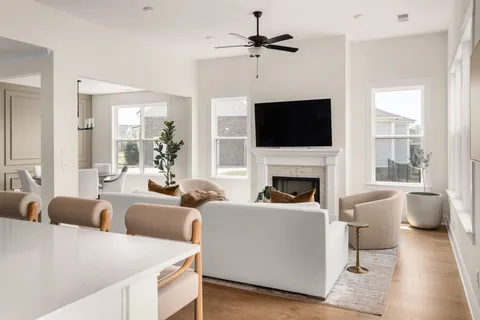 a living room with furniture a flat screen tv and a fireplace