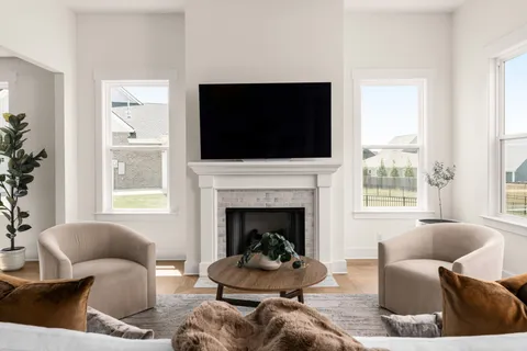 a living room with furniture a fireplace and a flat screen tv