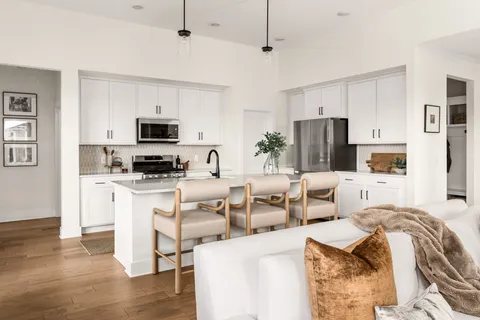 a kitchen with a dining table chairs and white cabinets