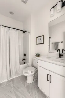 a bathroom with a double vanity sink a mirror a bathtub and shower
