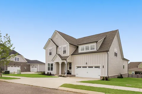 a view of a big house with a big yard and large trees