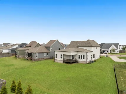 a view of a white house with a yard and plants