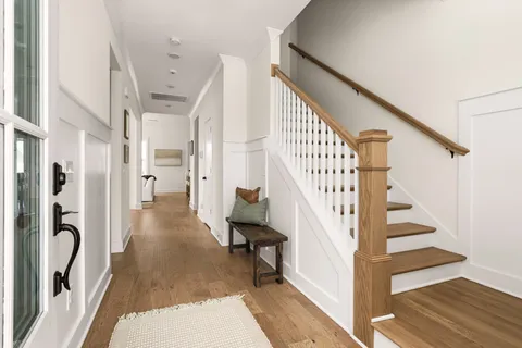 a living room with furniture a large window and wooden floors