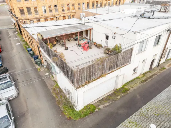 an aerial view of residential house with parking and trees