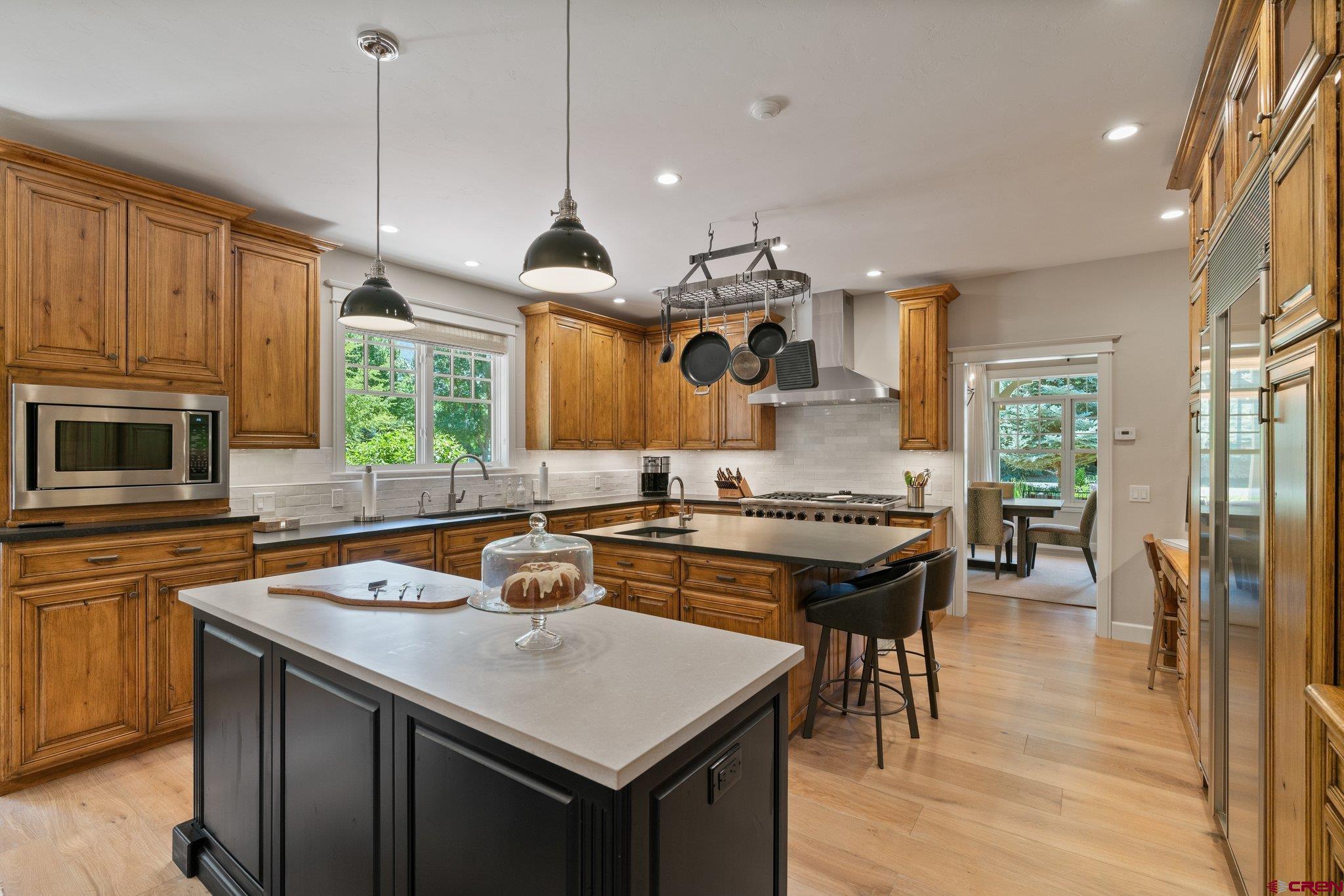 385 Red Rock Road Durango, CO 81301 - Photo 15 of 35 a kitchen with a stove a sink dishwasher a refrigerator and a dining table with chairs