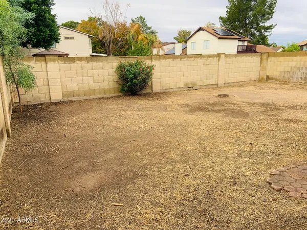 a view of a yard with wooden fence