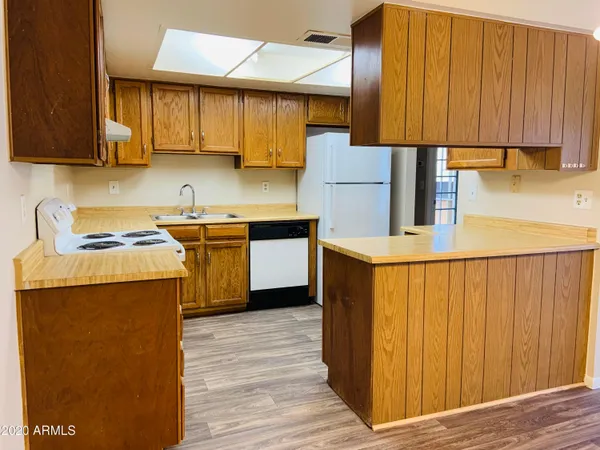 a kitchen with stainless steel appliances granite countertop wooden cabinets a stove a sink and a refrigerator