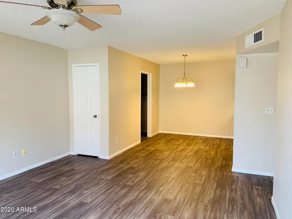 a view of a room with wooden floor and a ceiling fan