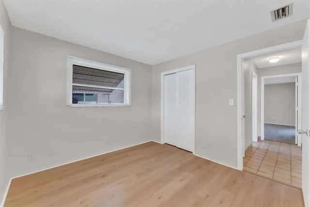 a view of empty room with wooden floor