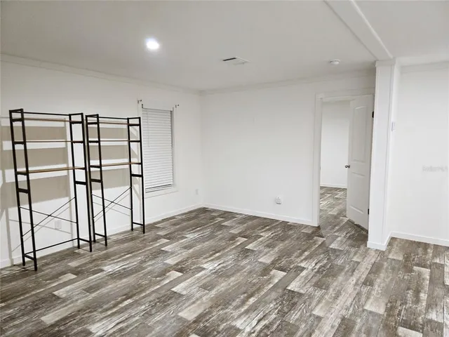 a view of empty room with wooden floor