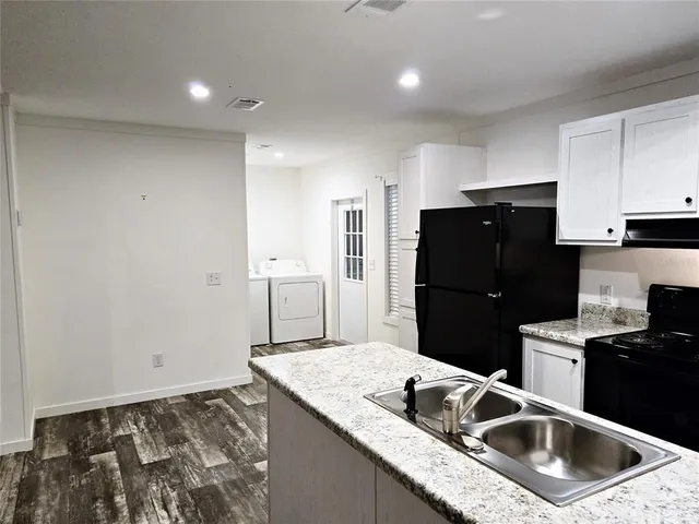 a kitchen with granite countertop a refrigerator and a sink