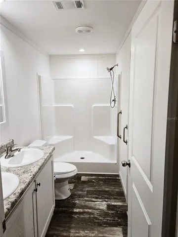 a bathroom with a granite countertop sink toilet and shower