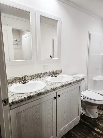 a bathroom with a granite countertop sink a toilet and a mirror