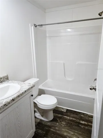 a bathroom with a granite countertop toilet and a shower