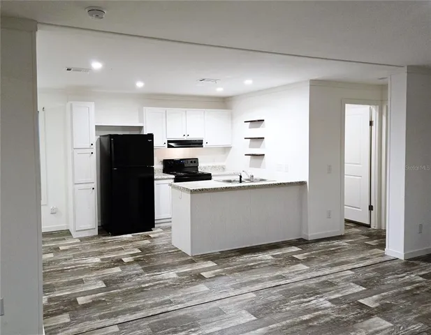 a view of a refrigerator in kitchen and wooden floor