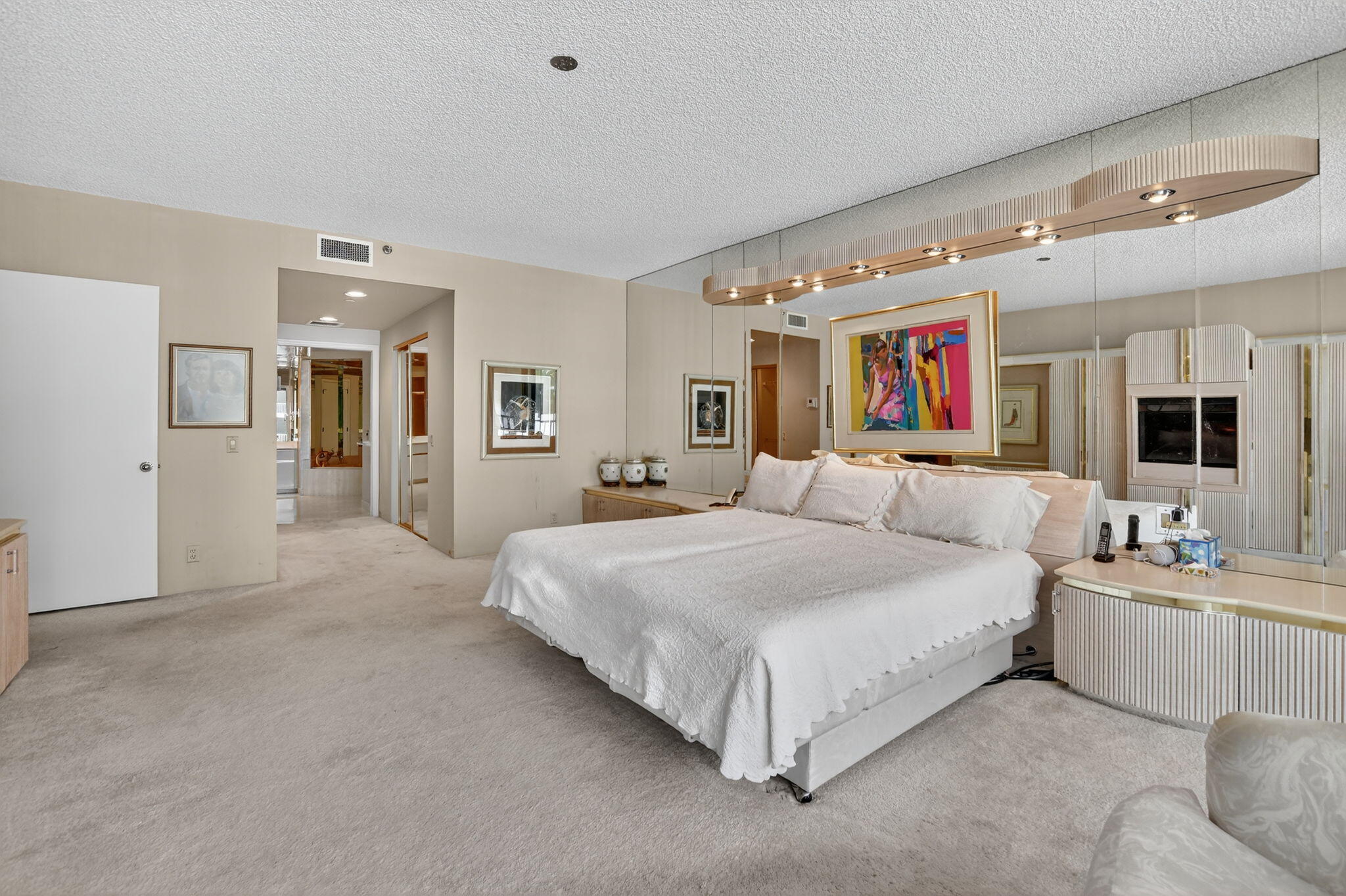 20310 Fairway Oaks Drive, Unit 124 Boca Raton, FL 33434 - Photo 33 of 65 a spacious bedroom with a bed couch and mirror