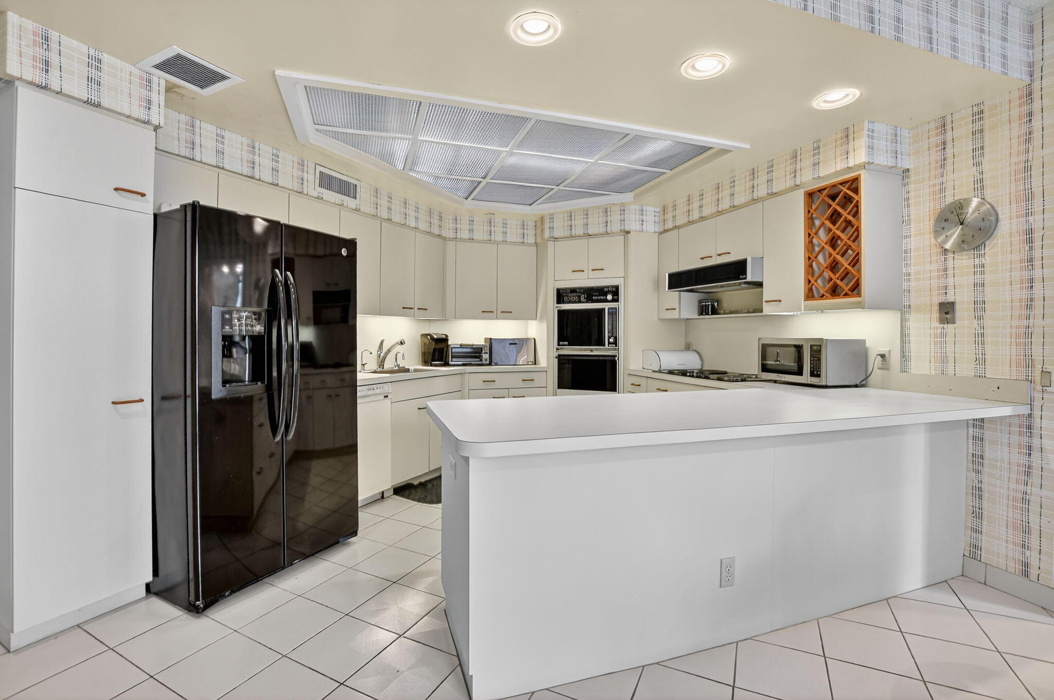 20310 Fairway Oaks Drive, Unit 124 Boca Raton, FL 33434 - Photo 39 of 65 a kitchen with kitchen island a refrigerator sink and cabinets