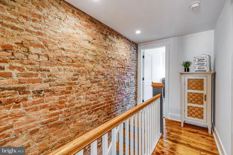 a view of a hallway with wooden floor and entryway