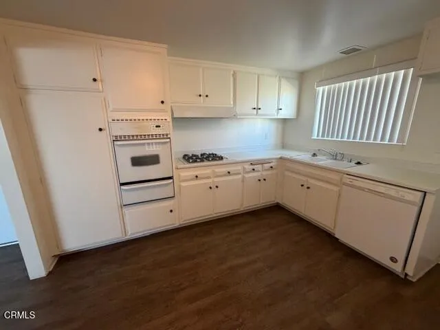 a kitchen with white cabinets and white appliances