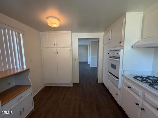 a kitchen with cabinets and wooden floor
