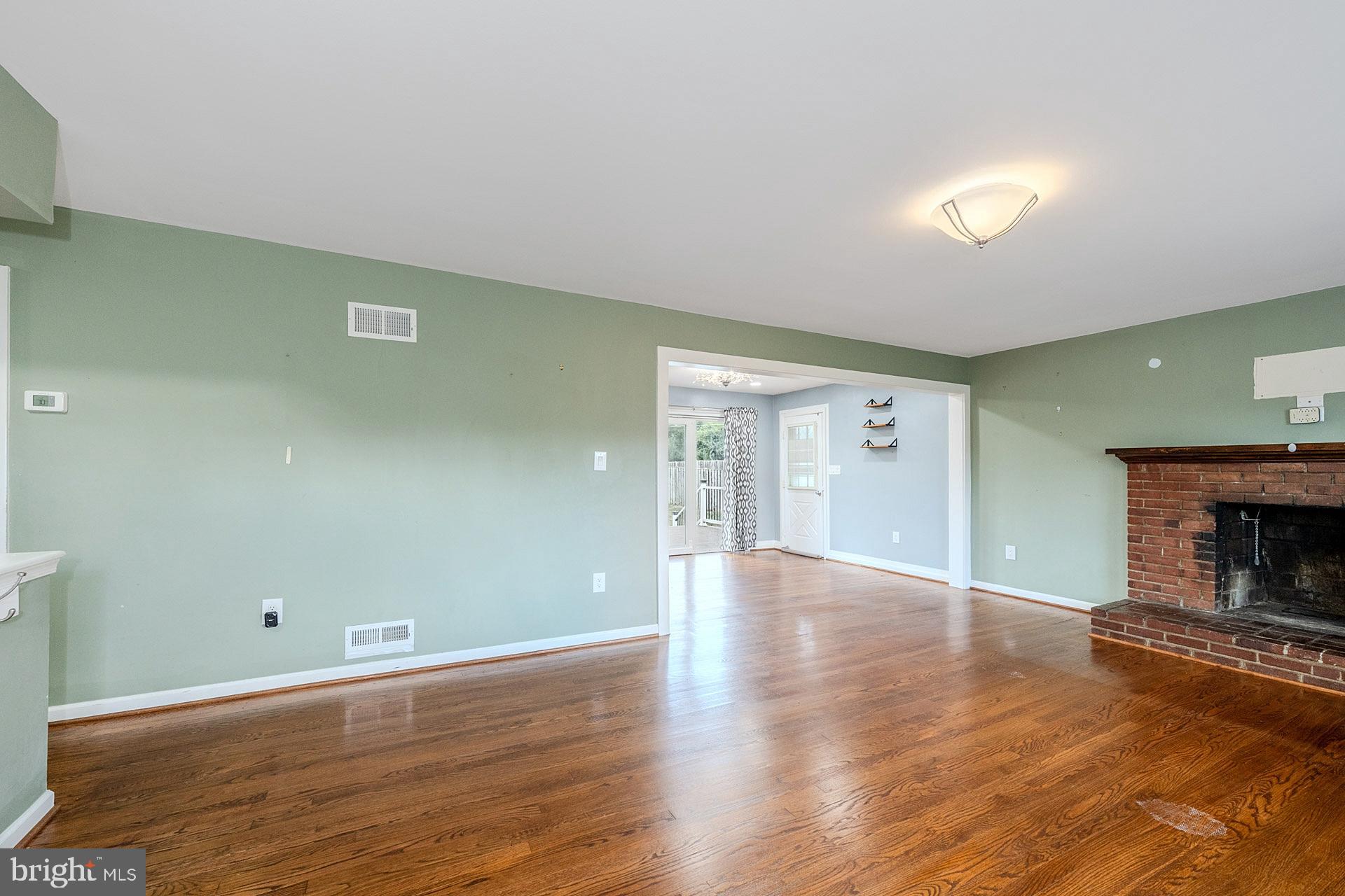 7625 Huron Drive Gainesville, VA 20155 - Photo 5 of 34 an empty room with wooden floor fireplace and windows